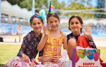 Children at a birthday party under outdoor shaded area